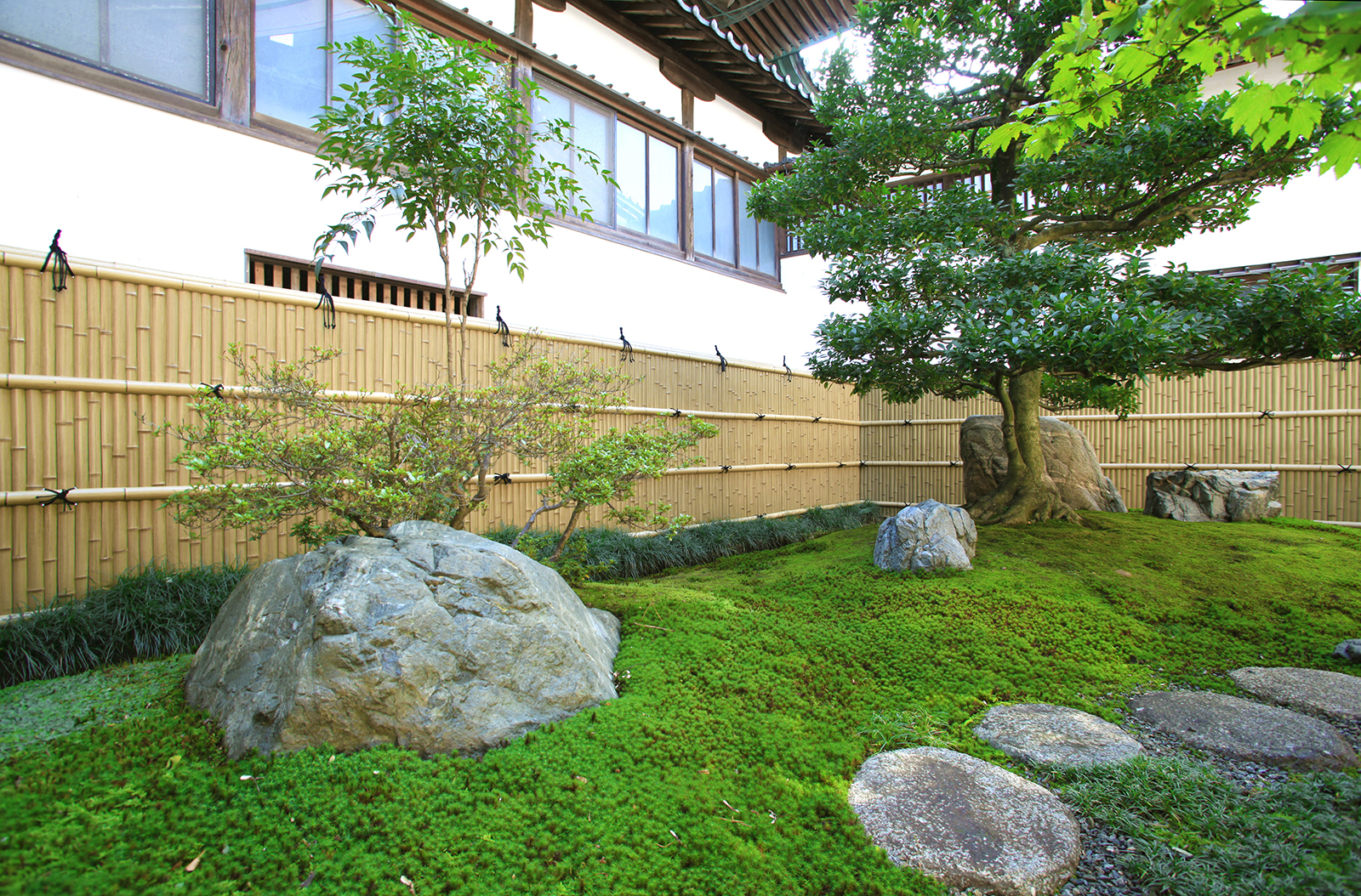 庭石がバランスよく配置された美しい和風庭園の背景に タカショー施工事例紹介