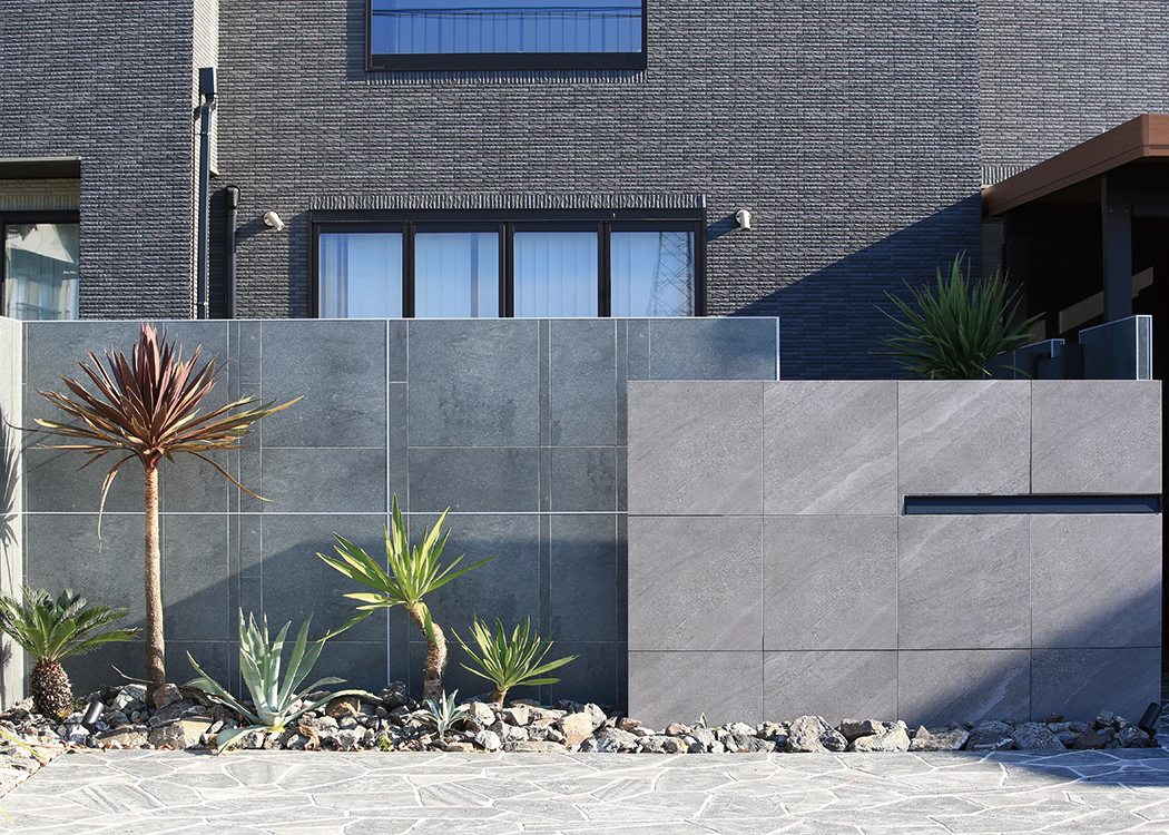 門まわりに、天然石調の落ち着いた印象のアヴェルサ タイルを使用