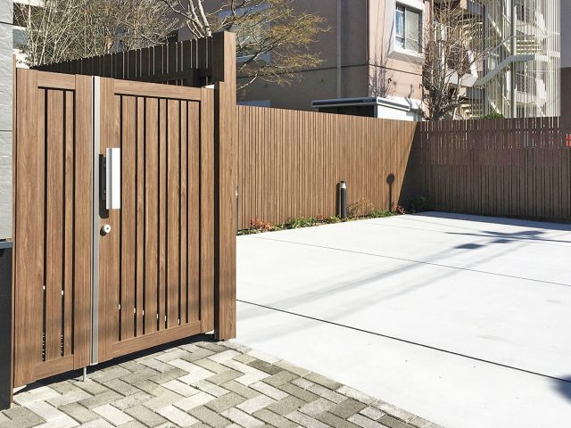 木目調アルミ材の門扉と板塀をコーディネート。エバーアートウッドフェンス縦貼ユニットの適度な隙間が光と風を通します