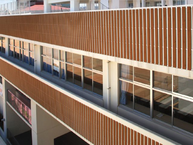 ウッドテイストの壁面材で、人の多く集まる学校施設のデザイン性を向上