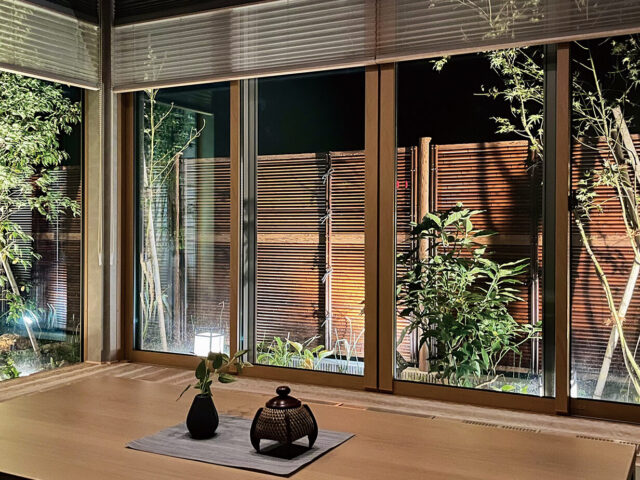 室内からライトアップされたe-バンブーみす垣（すす竹）を眺める。静寂な空間を楽しみます